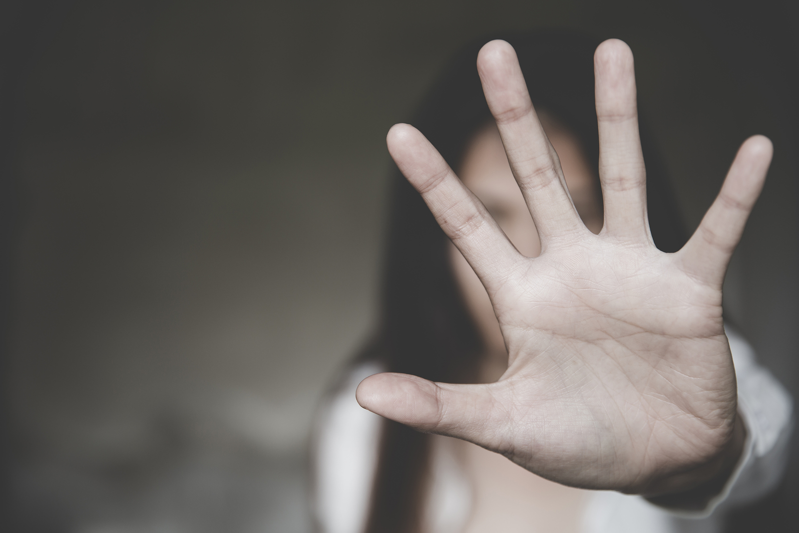 a woman holding up her hand against violence