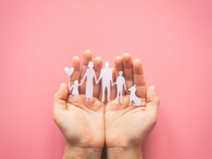 hands holding a paper family cutout