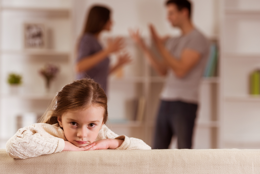 man and woman arguing behind child