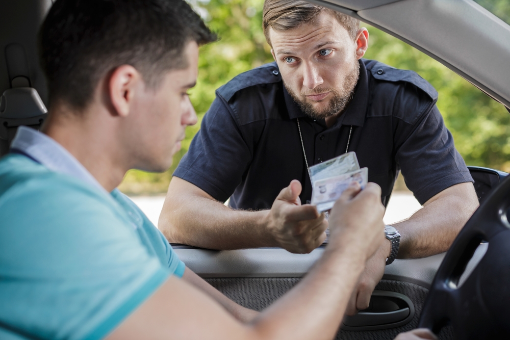 driver handing over license to policeman