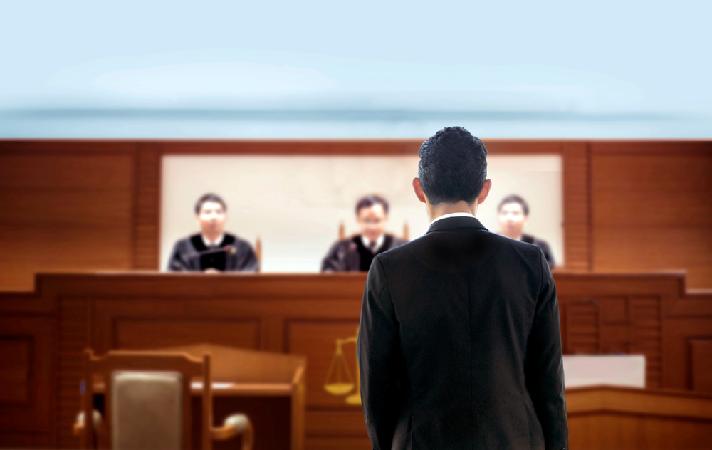 person in court speaking to a panel of judges