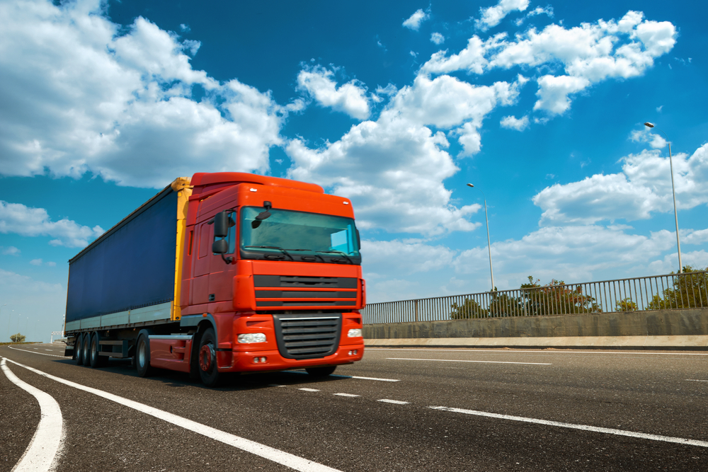 red commercial truck on the highway