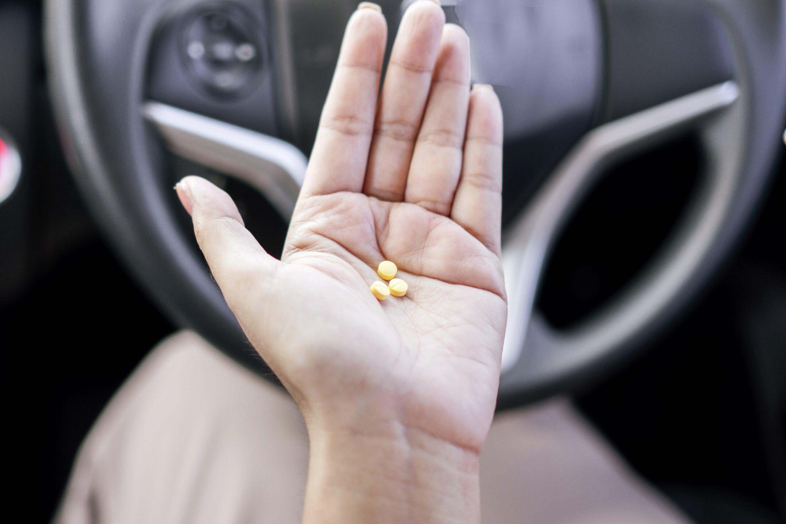 Texas woman behind the wheel of a car with prescription drugs in her hands.