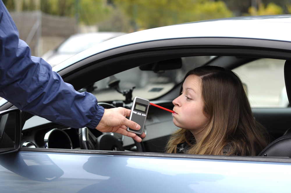 A Denton motorist performs a breathalyzer test with police during a traffic stop. A Denton DWI lawyer can challenge the validity of the test to have DWI charges lessened or cleared.