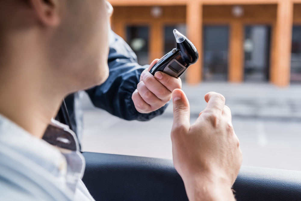 A Fort Worth policeman administers a breathalyzer test to a motorist during a traffic stop. With the help of a DWI attorney in Fort Worth, the accuracy of all testing can be challenged.